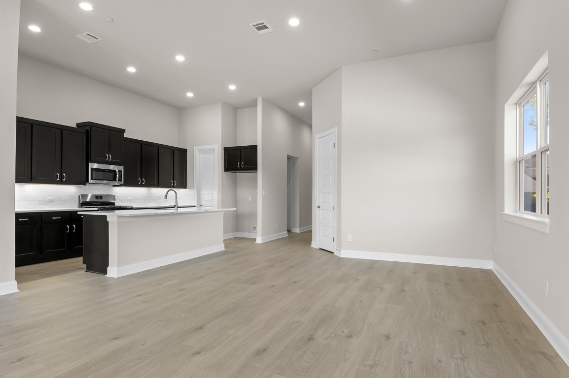 600 C-Bar Ranch Trail, Unit 122 Cedar Park, TX 78613 - Photo 11 of 31 a large white kitchen with a large window and stainless steel appliances