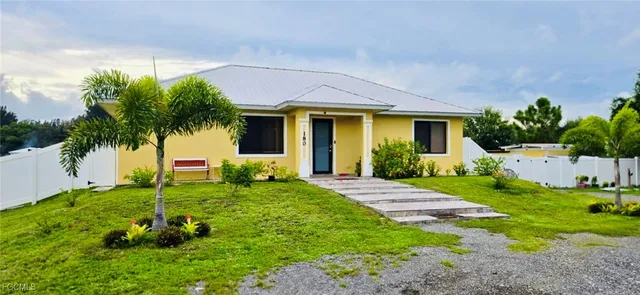 a view of a house with a yard and potted plants