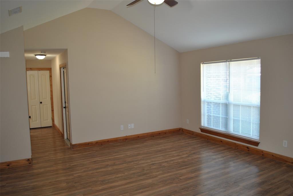 515 East Liberty Street Pilot Point, TX 76258 - Photo 12 of 25 a view of an empty room with wooden floor and a window