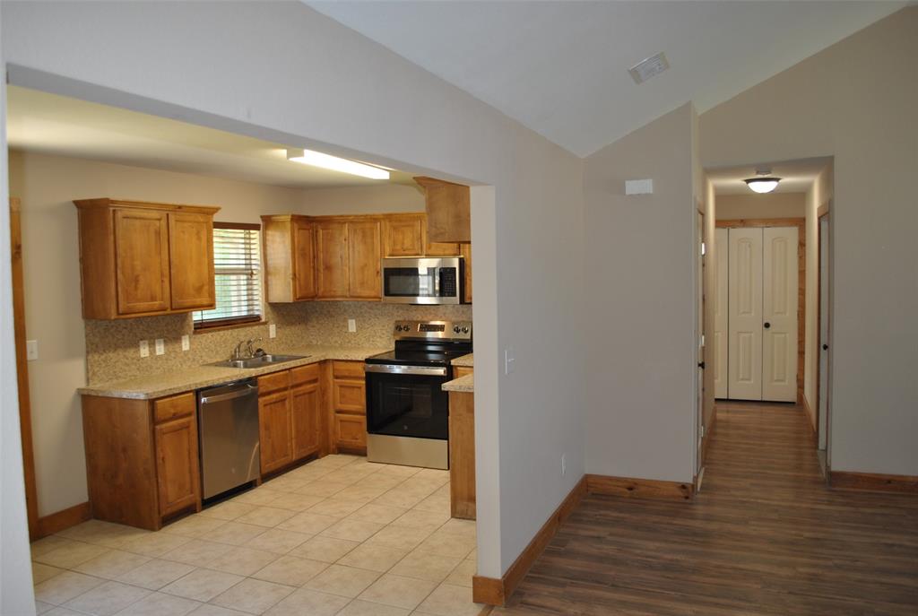 515 East Liberty Street Pilot Point, TX 76258 - Photo 13 of 25 a kitchen with stainless steel appliances granite countertop a sink stove and refrigerator