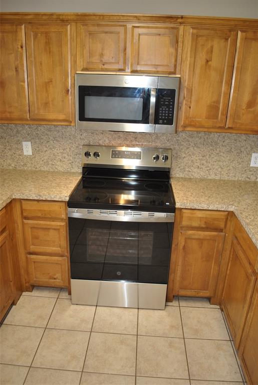 515 East Liberty Street Pilot Point, TX 76258 - Photo 15 of 25 a kitchen with a stove and a microwave