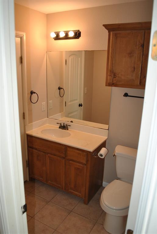 515 East Liberty Street Pilot Point, TX 76258 - Photo 22 of 25 a bathroom with a sink a toilet and mirror