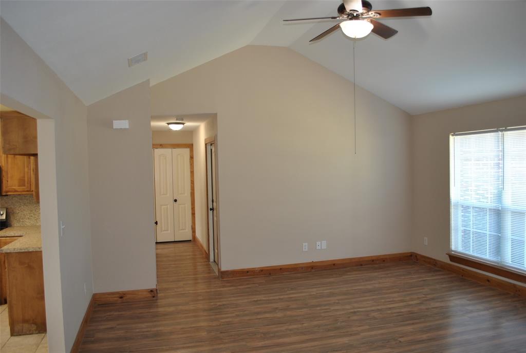 515 East Liberty Street Pilot Point, TX 76258 - Photo 3 of 25 a view of an empty room with wooden floor and window