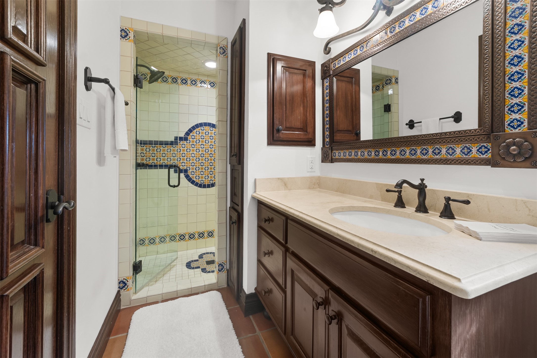 34000 Smithson Valley Road Bulverde, TX 78163 - Photo 24 of 50 The secondary bath showcases custom cabinetry, stone countertops, and colorful artisan tile accents that complement the home's Mediterranean character. A stylish and functional space for guests or family members.