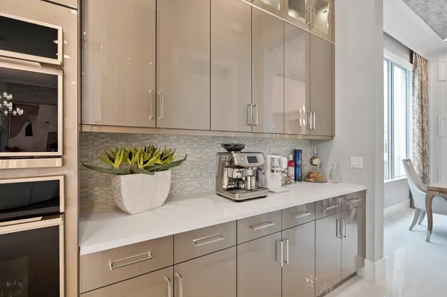 a view of a dining room with furniture a chandelier and large windows