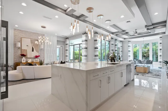 a spacious bedroom with a bed a mirror and a chandelier