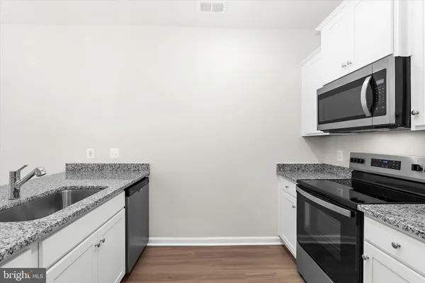 a kitchen with stainless steel appliances granite countertop a sink a refrigerator and a granite counter tops