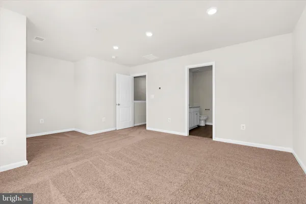 a bathroom with a granite countertop sink a toilet and a large mirror