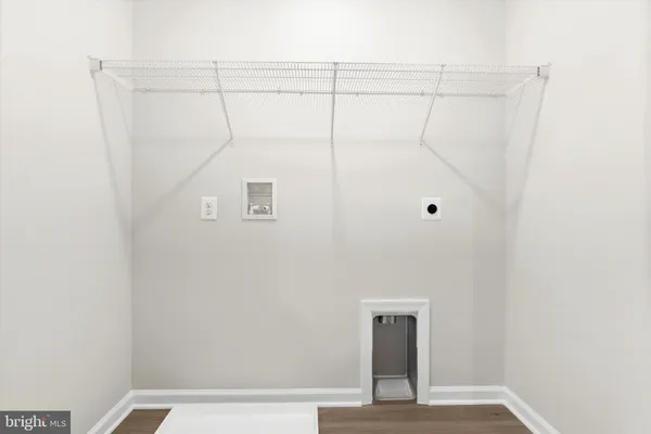 a view of a room with a ceiling fan and wooden floor