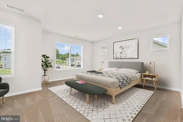 a spacious bedroom with a bed and wooden floor