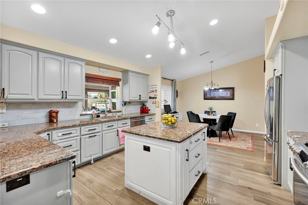 17777 Brazier Drive Riverside, CA 92508 - Photo 15 of 55 a kitchen with stainless steel appliances granite countertop a table chairs sink and cabinets