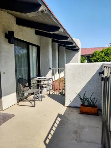 a view of the patio with a table and chairs under an umbrella