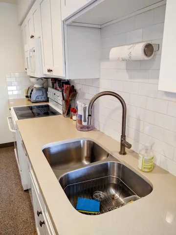 a kitchen with a sink and a stove top oven