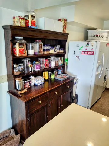 a kitchen with a refrigerator and a shelf