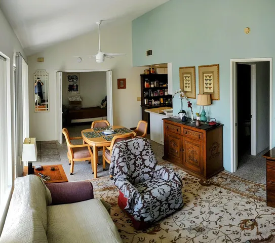 a living room with furniture a flat screen tv and kitchen view