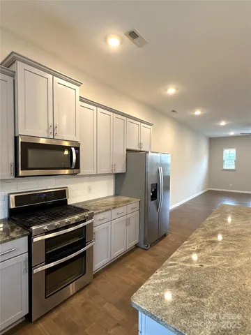 a bathroom with a granite countertop sink mirror and a bathtub