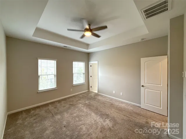 an empty room with closet and a chandelier fan