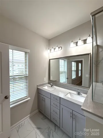 a bathroom with a shower sink and mirror