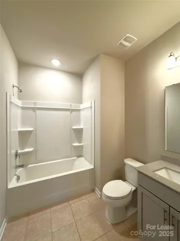 a view of empty room with wooden floor and kitchen view