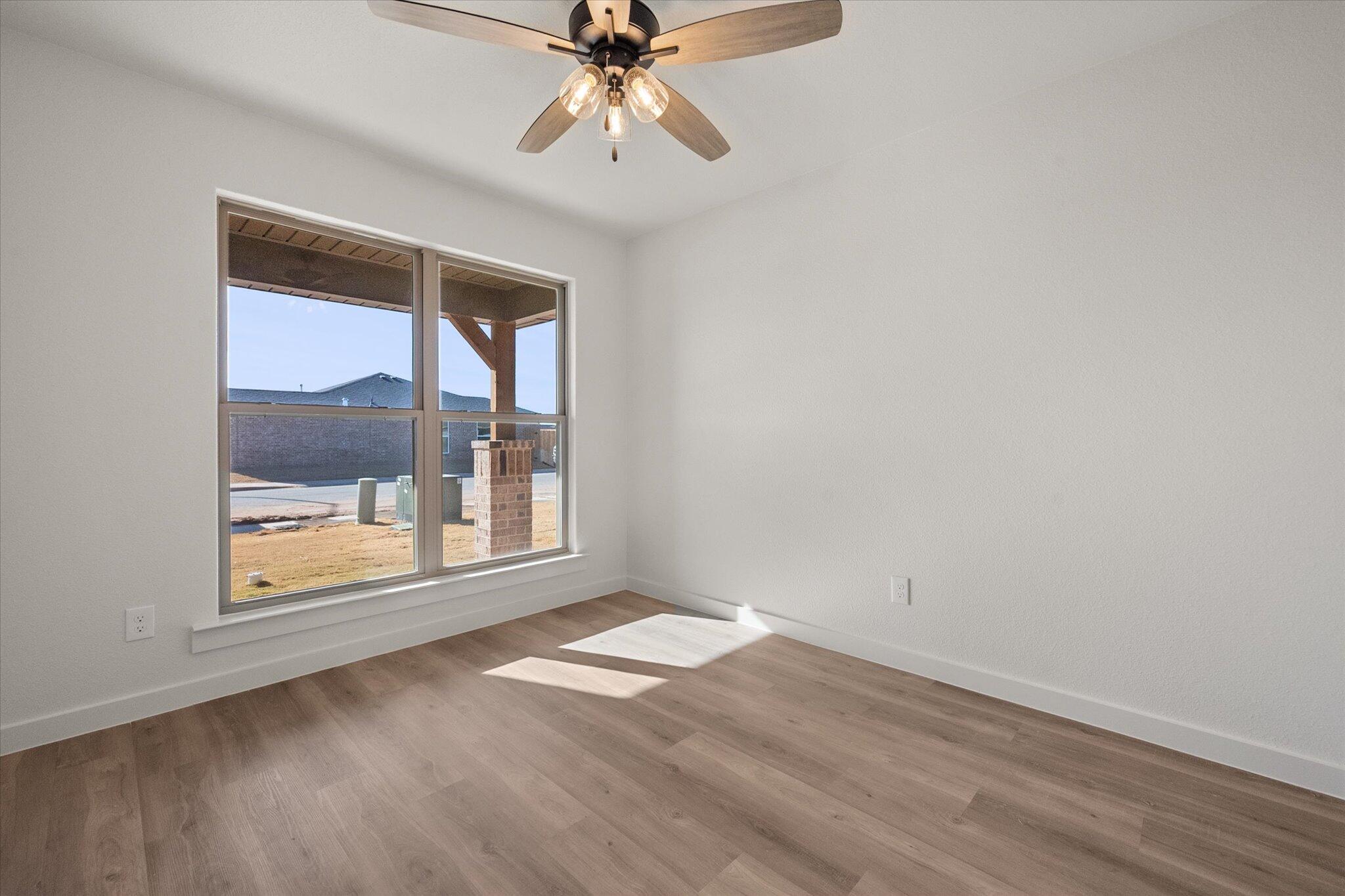 3102 138th Place Lubbock, TX 79423 - Photo 16 of 21 an empty room with wooden floor fan and windows