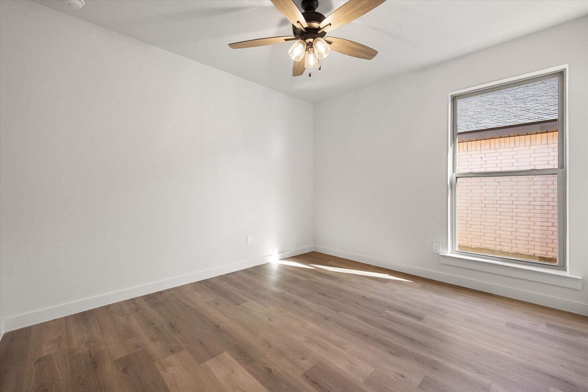 3102 138th Place Lubbock, TX 79423 - Photo 17 of 21 wooden floor in an empty room with a window