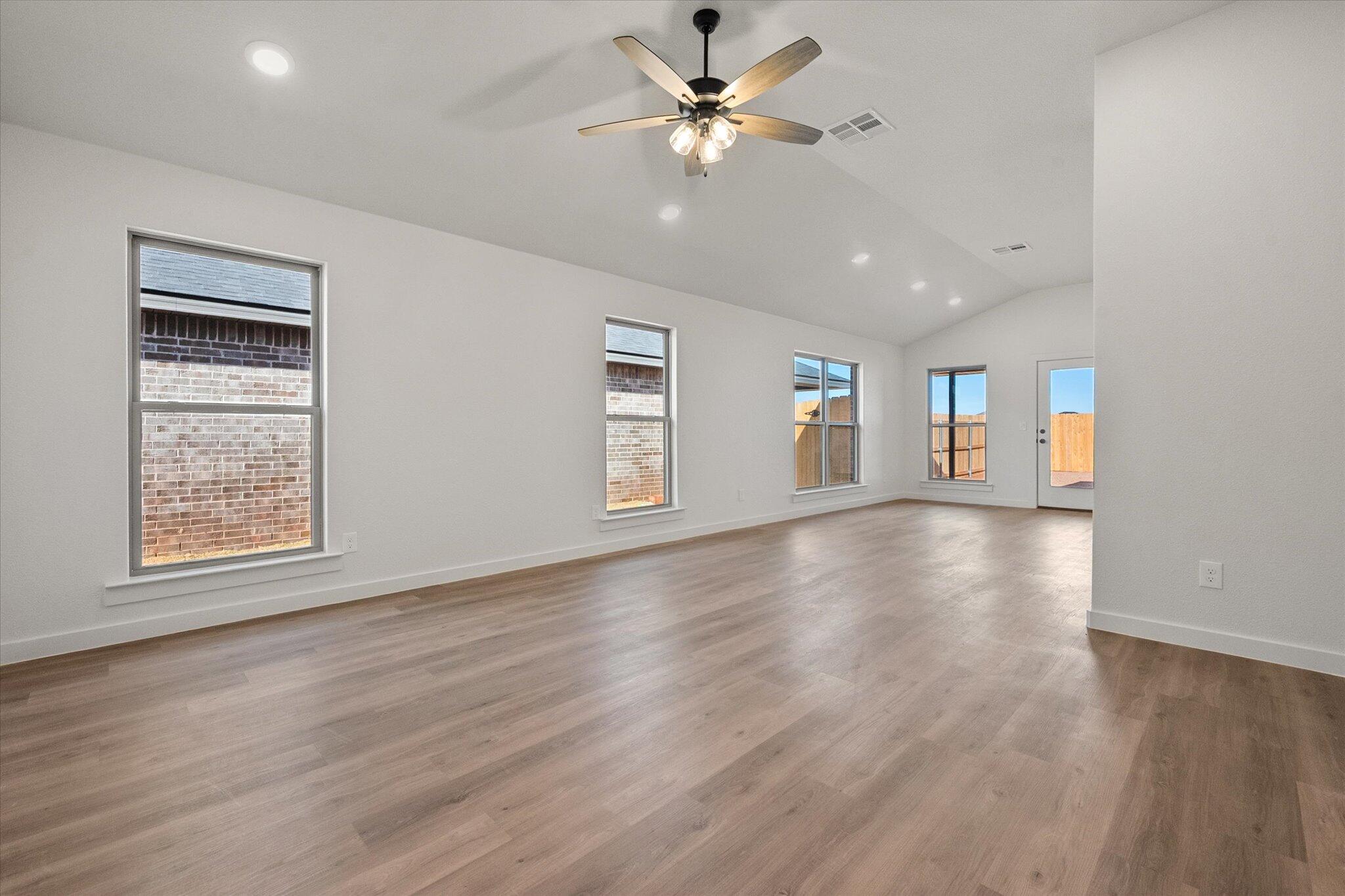3102 138th Place Lubbock, TX 79423 - Photo 3 of 21 a view of an empty room with a window and wooden floor