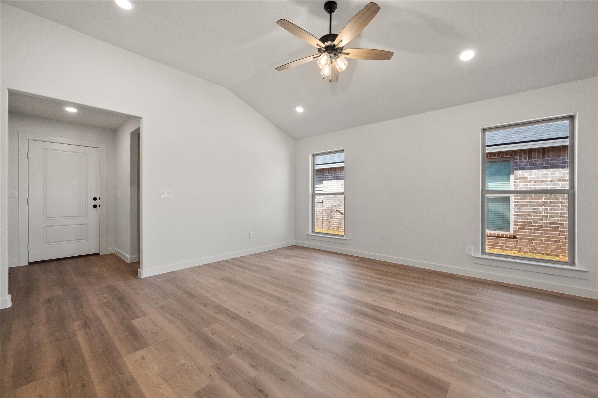 3102 138th Place Lubbock, TX 79423 - Photo 5 of 21 a view of an empty room with a window and wooden floor