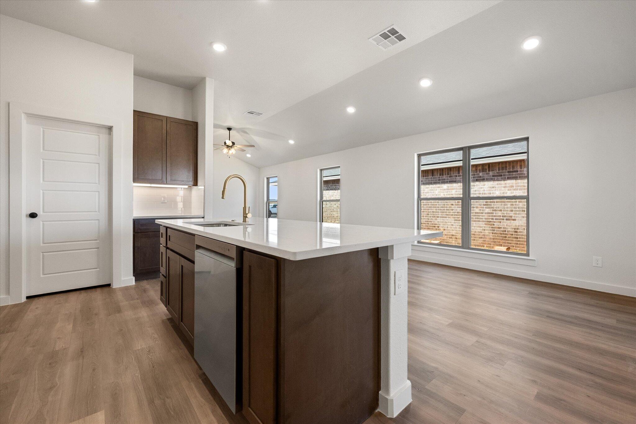 3102 138th Place Lubbock, TX 79423 - Photo 10 of 21 a kitchen with kitchen island granite countertop a sink cabinets and wooden floor