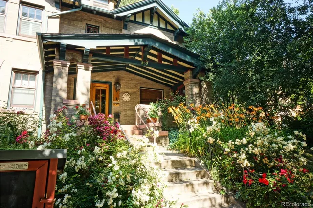 a front view of a house with a yard and fountain in middle