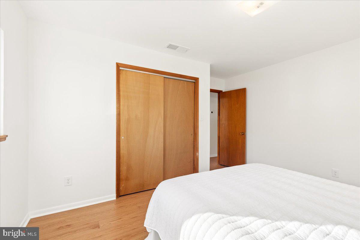 723 207th Street Pasadena, MD 21122 - Photo 20 of 42 a bedroom with a bed and wooden floor
