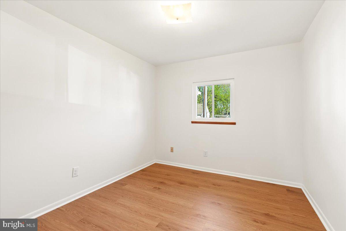 723 207th Street Pasadena, MD 21122 - Photo 23 of 42 an empty room with wooden floor and window