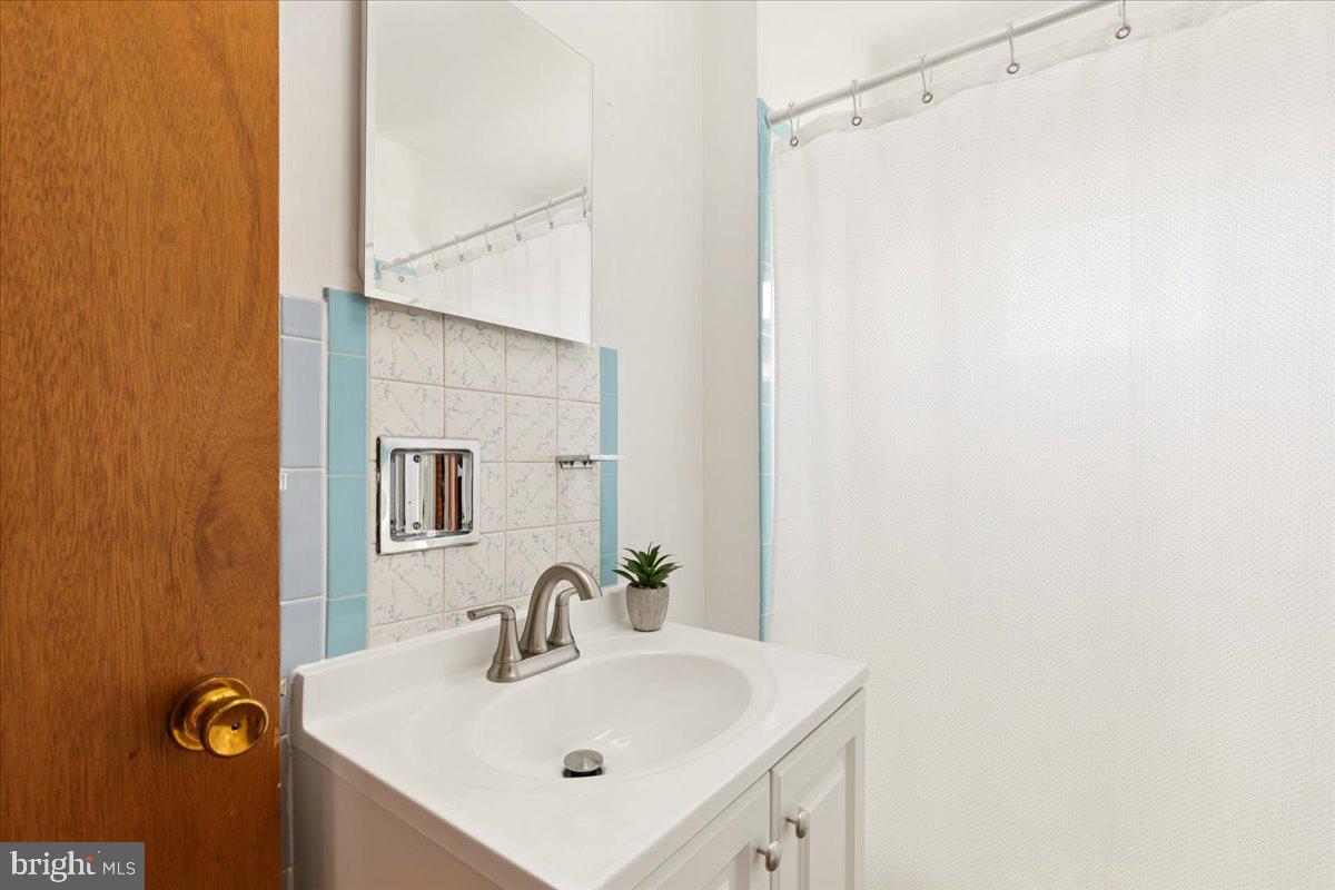 723 207th Street Pasadena, MD 21122 - Photo 32 of 42 a bathroom with a sink and a mirror