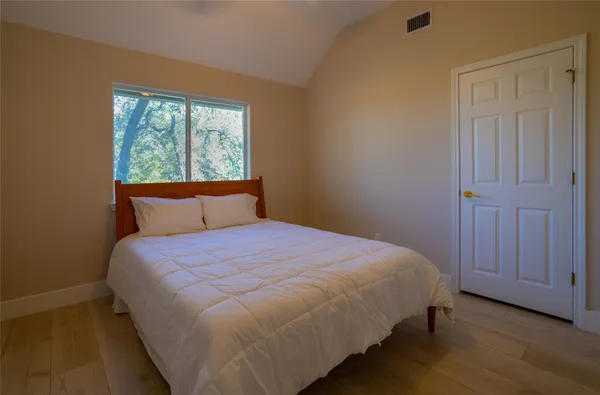 a large bed sitting in a bedroom next to a window