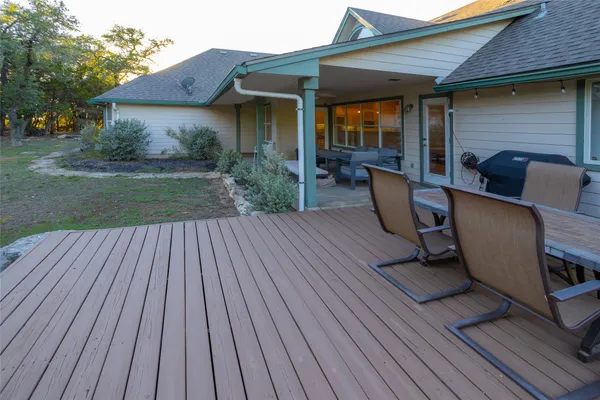 a view of a patio with table and chairs wooden floor and fence