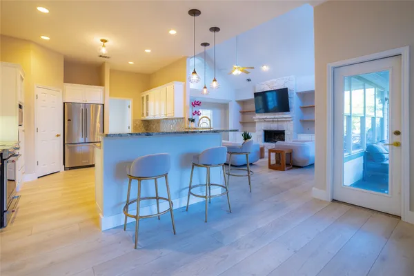 a large kitchen with cabinets wooden floor and stainless steel appliances