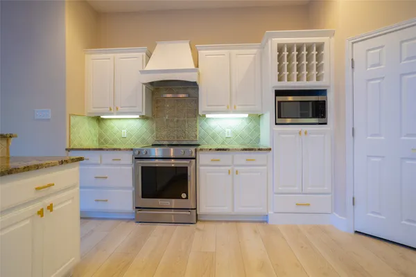 a kitchen with granite countertop white cabinets and white appliances