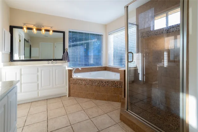 a bathroom with a granite countertop bathtub and shower