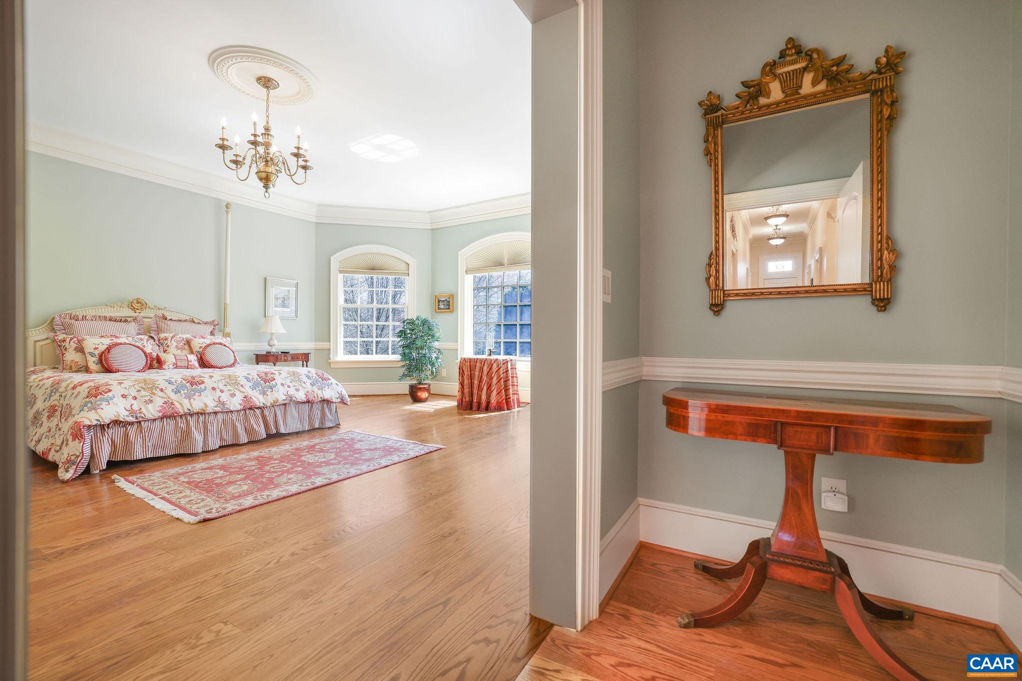 6385 Indian Ridge Drive Earlysville, VA 22936 - Photo 19 of 48 a bedroom with a bed and a chandelier
