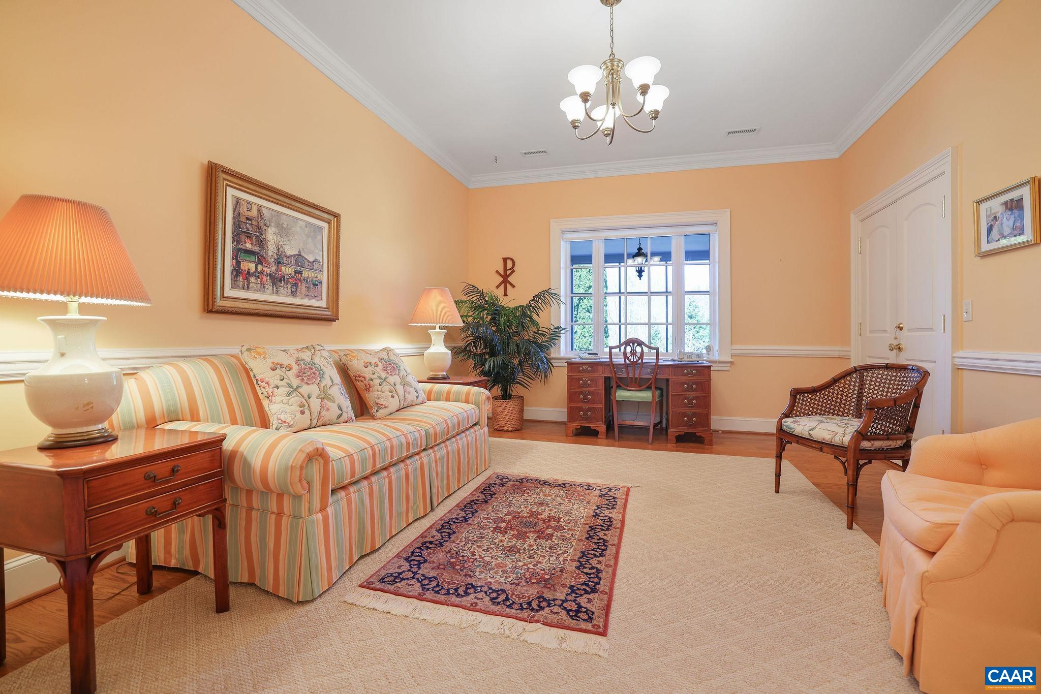 6385 Indian Ridge Drive Earlysville, VA 22936 - Photo 30 of 48 a living room with furniture a chandelier and a dining room