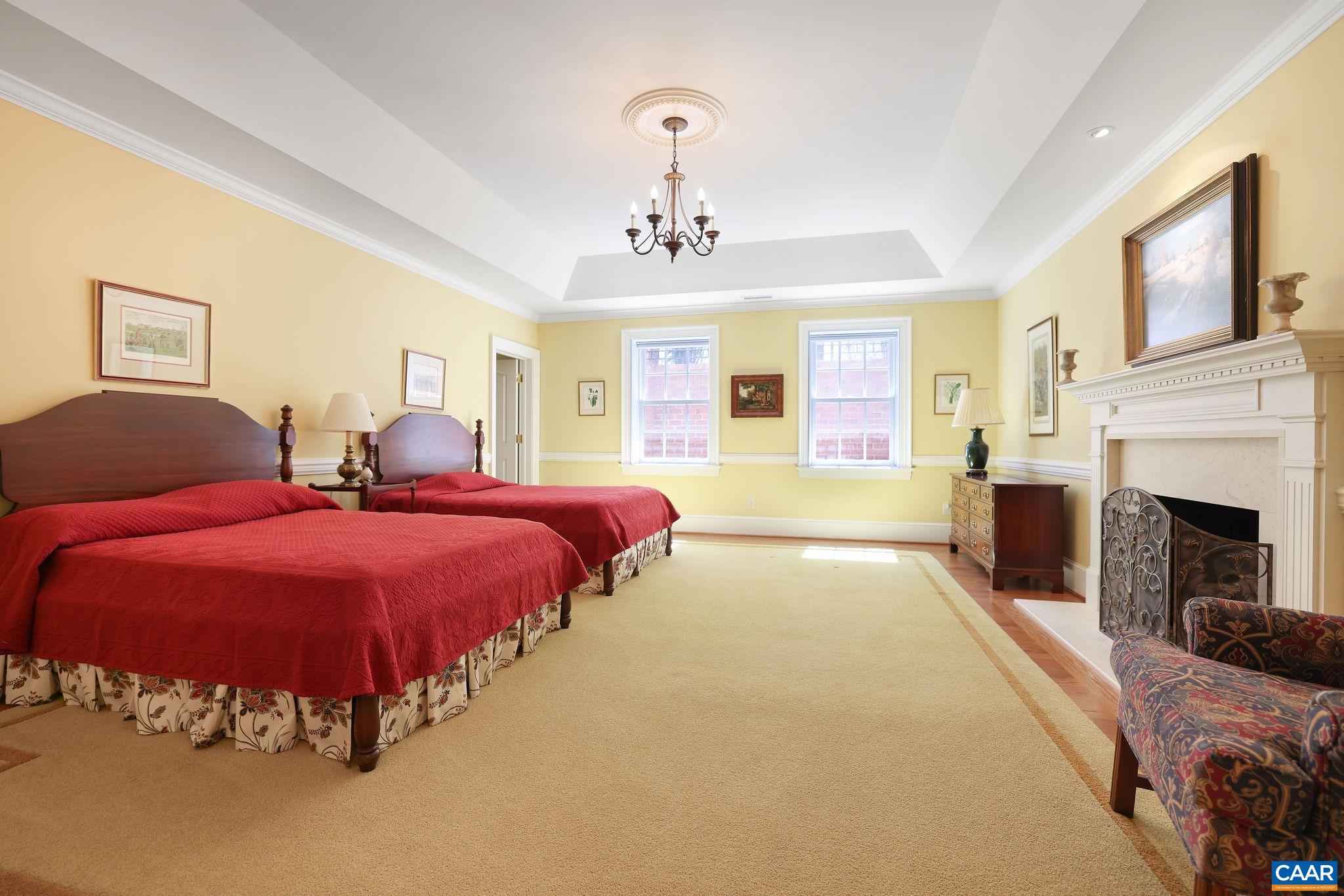 6385 Indian Ridge Drive Earlysville, VA 22936 - Photo 32 of 48 a spacious bedroom with a bed and a fireplace