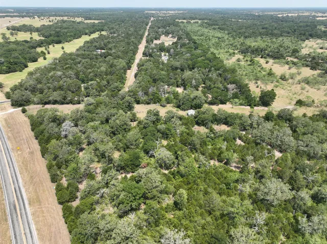 an aerial view of residential houses with outdoor space and trees
