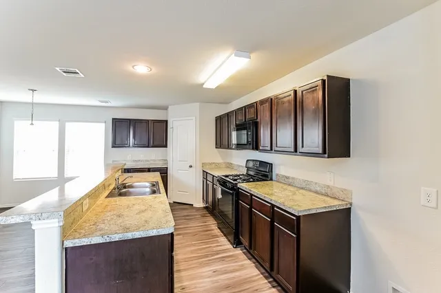 a kitchen with sink stove and granite counter top