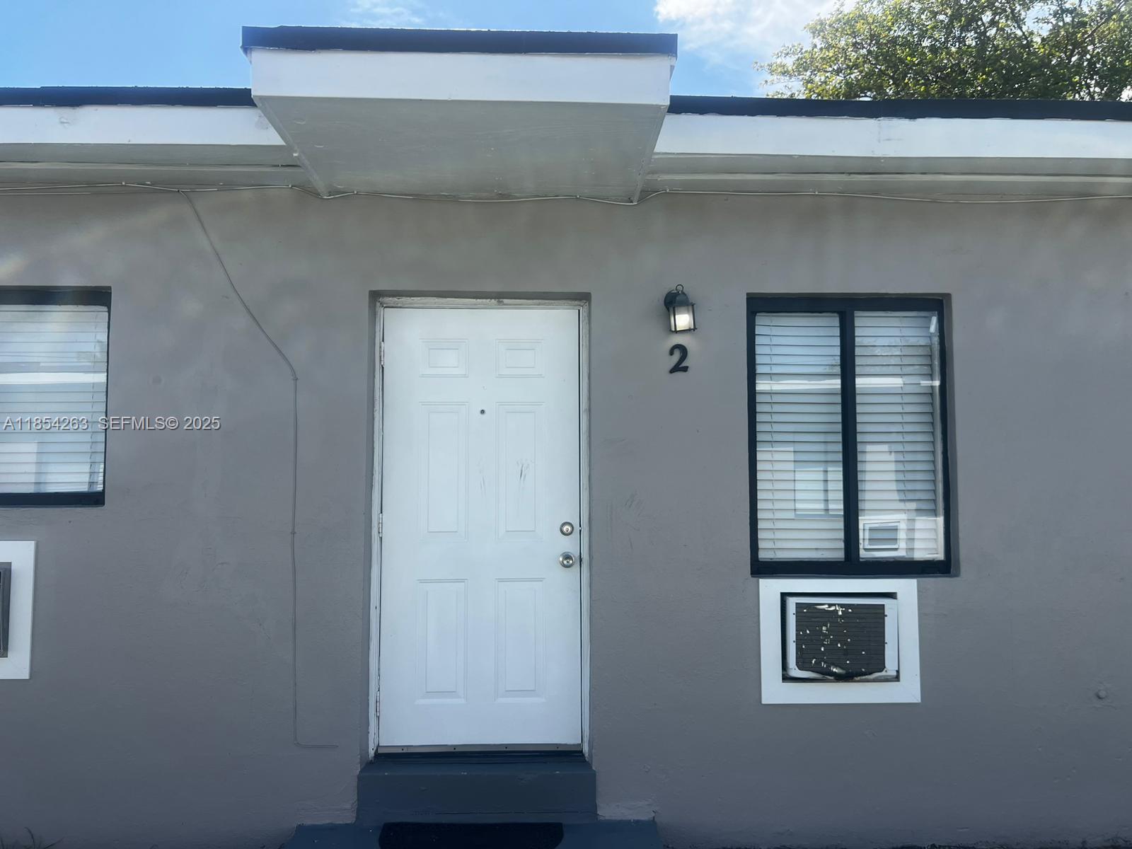 2090 Northwest 31st Street, Unit 2 Miami, FL 33142 - Photo 2 of 10 a house with windows and a cabinet