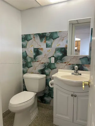 a bathroom with a toilet sink and mirror