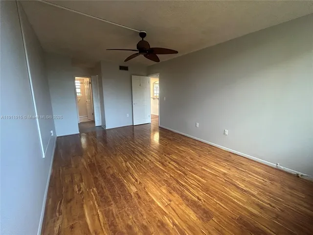 wooden floor in an empty room with a chandelier