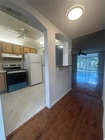 wooden floor in an empty room with a kitchen