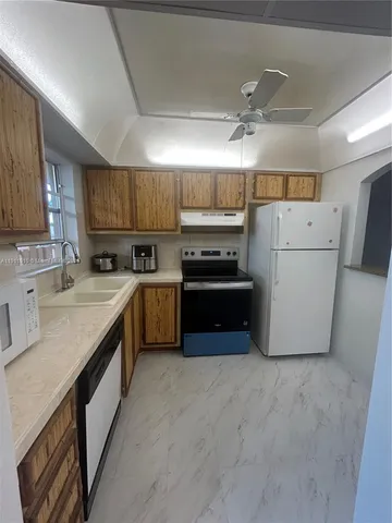 a kitchen with a refrigerator sink and cabinets