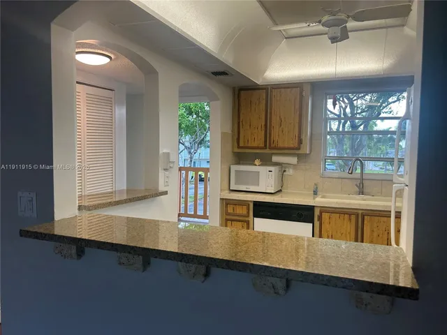 a kitchen with counter top space and windows