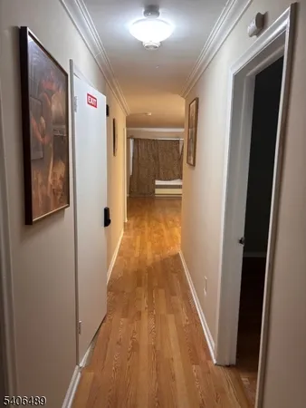 a view of a hallway with wooden floor and staircase