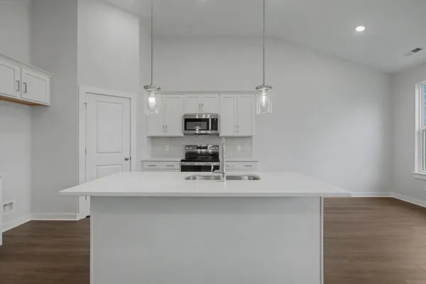 a kitchen with white cabinets and stainless steel appliances